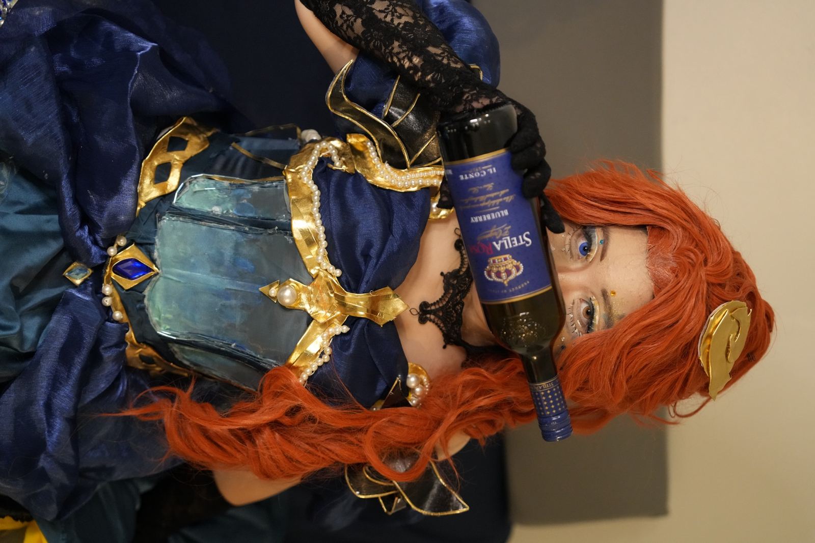 Yuxuan Du in an orange-haired fantasy cosplay holding a blue bottle